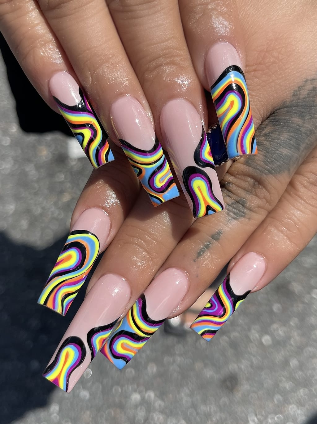 Coffin nails with swirling rainbow tie dye marble design at Palace Nail Spa in Midtown Tallahassee