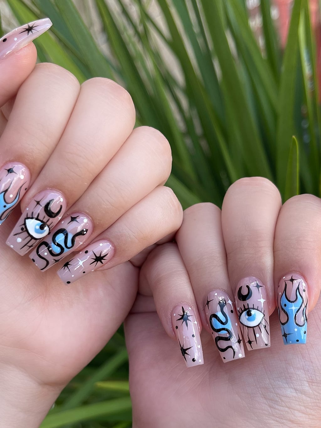 Nude coffin nails with black line art eyes and stars at Palace Nail Spa