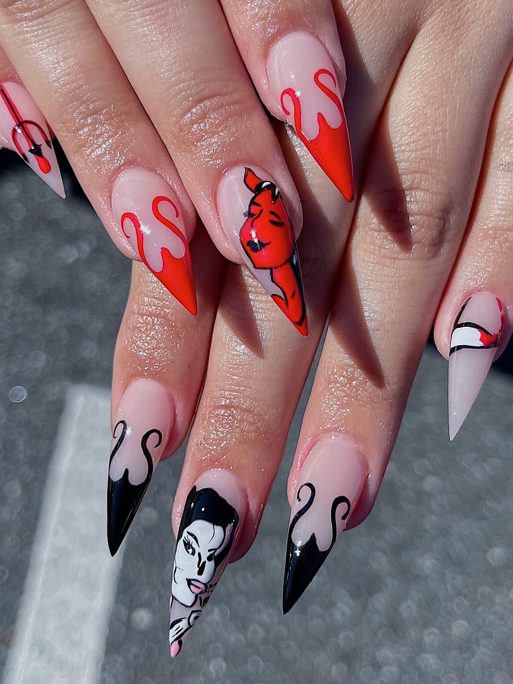 Stiletto nails with red and black flames and gothic character art at Palace Nail Spa