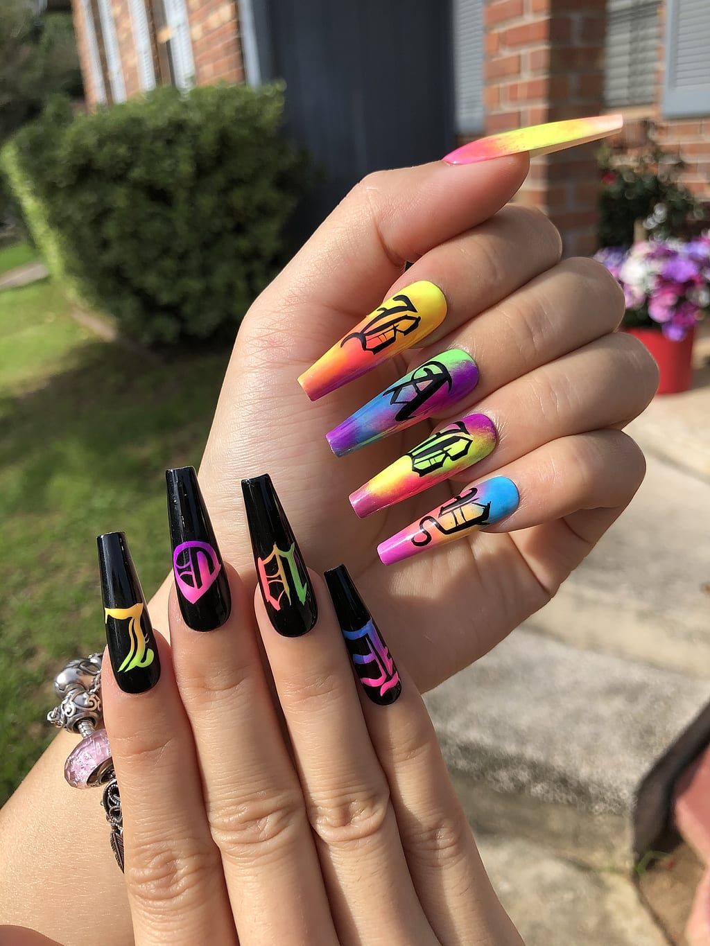 Long black coffin nails with neon graffiti letters and symbols at Palace Nail Spa in Tallahassee