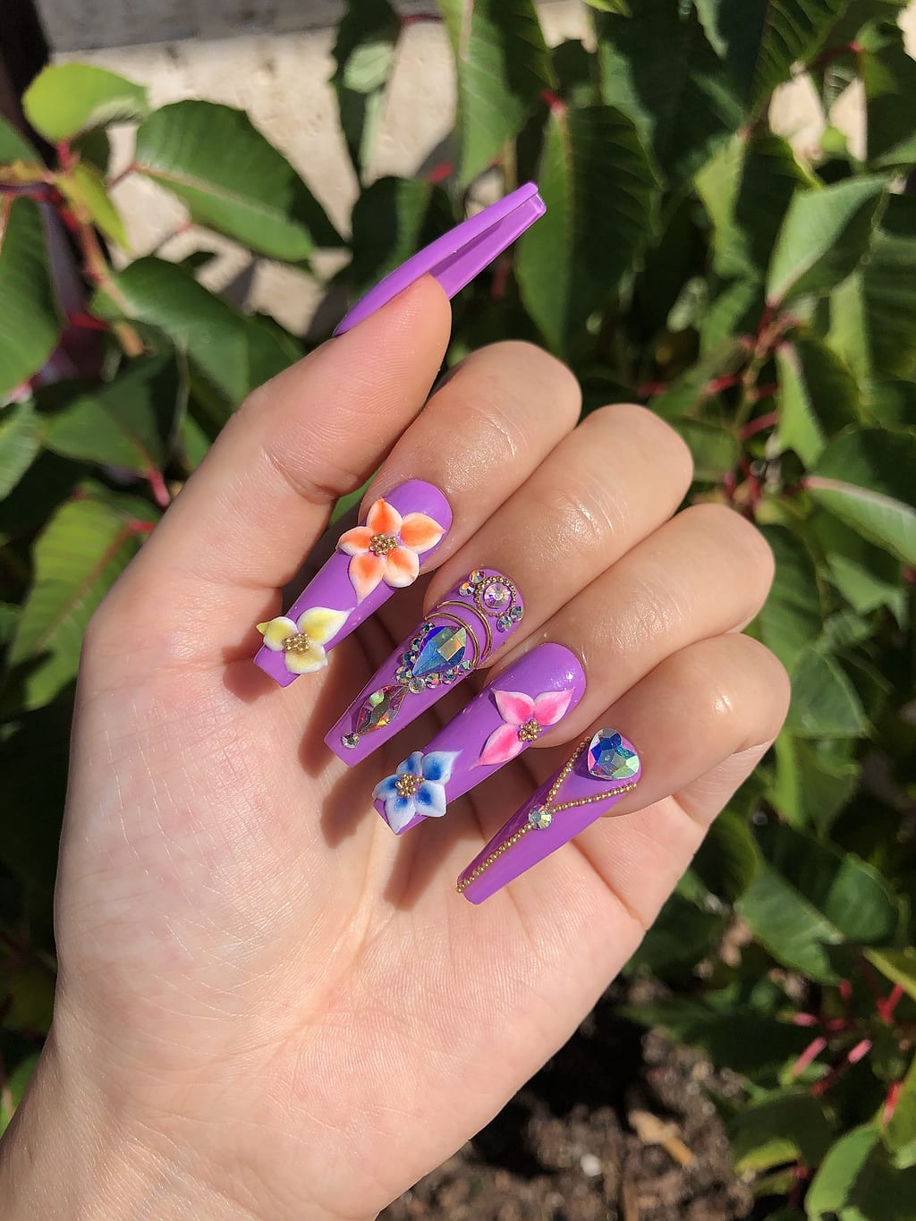 Coffin nails with purple 3D flowers and butterfly charms at Palace Nail Spa in Midtown Tallahassee
