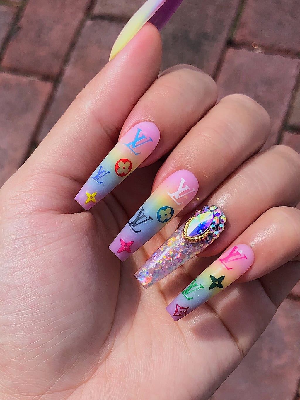 Pastel pink and blue coffin nails with playful cartoon charms at Palace Nail Spa in Tallahassee