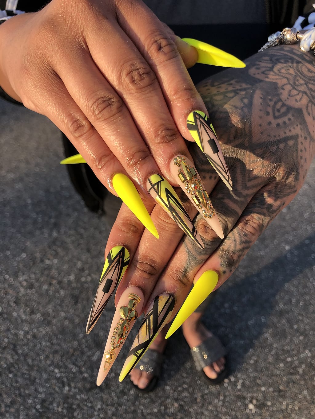 Yellow and gold stiletto nails show bold abstract art at Palace Nail Spa in Midtown Tallahassee