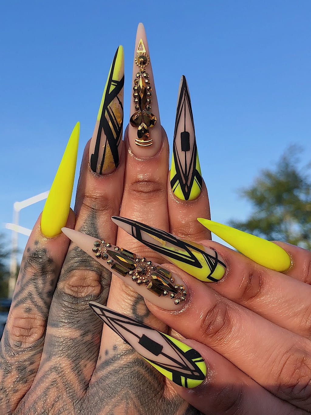 Yellow and black stiletto nails feature bold geometric art at Palace Nail Spa in Midtown Tallahassee