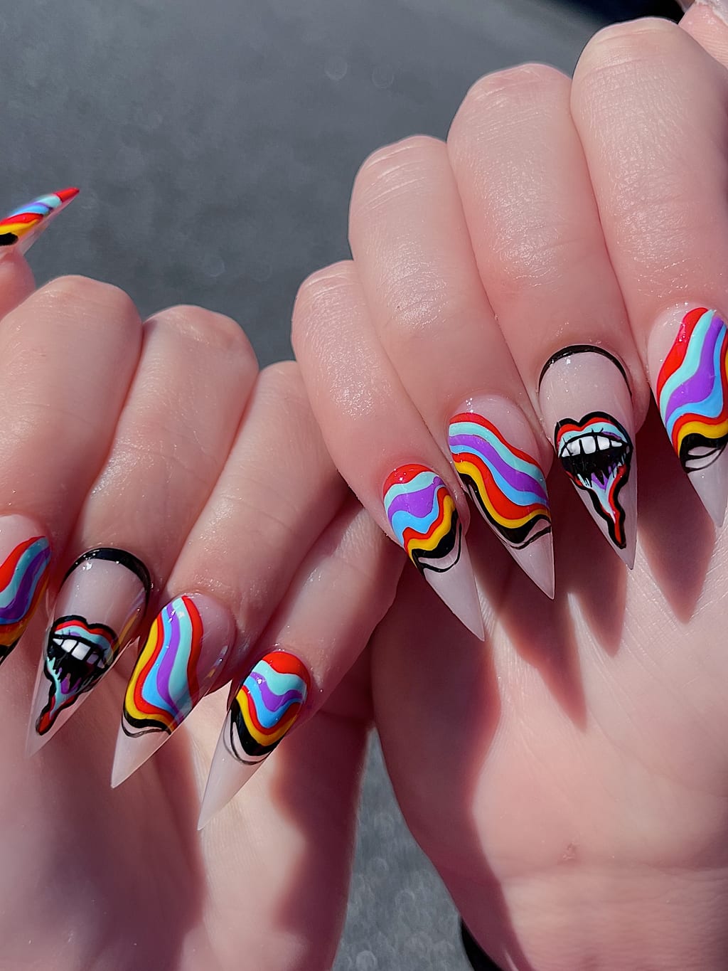 Long nails feature rainbow swirls and painted lips in pop art style at Palace Nail Spa