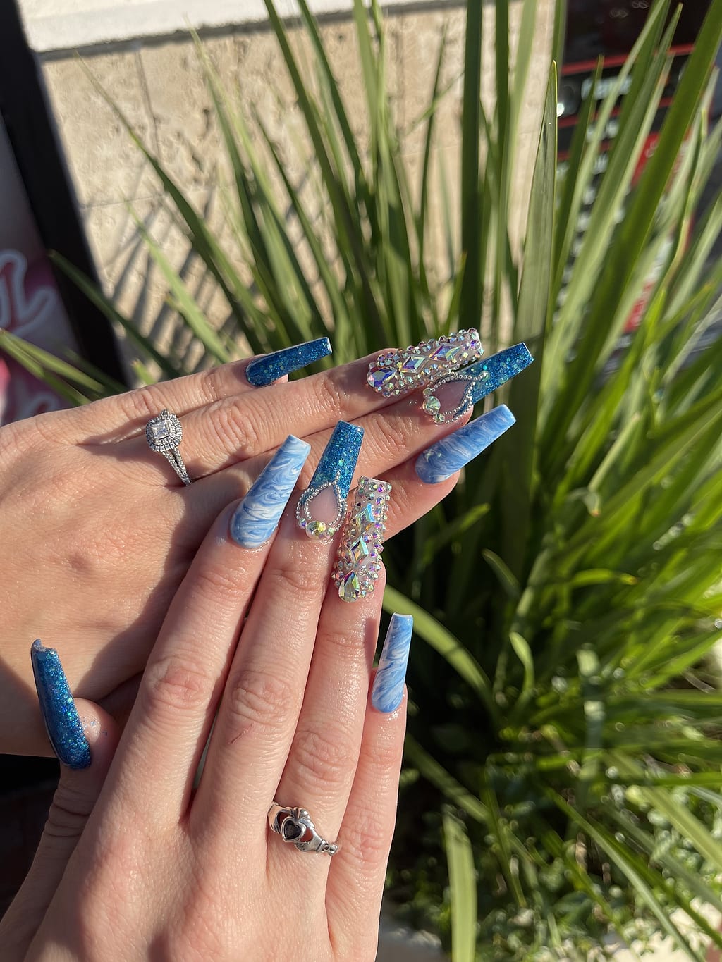 Light blue coffin nails sparkle with silver glitter and rhinestones at Palace Nail Spa in Tallahassee