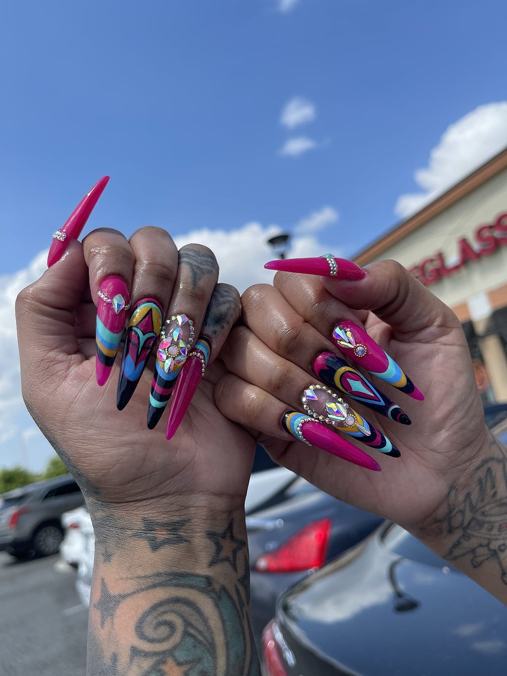 Pink and black almond nails feature colorful abstract art at Palace Nail Spa in Midtown Tallahassee