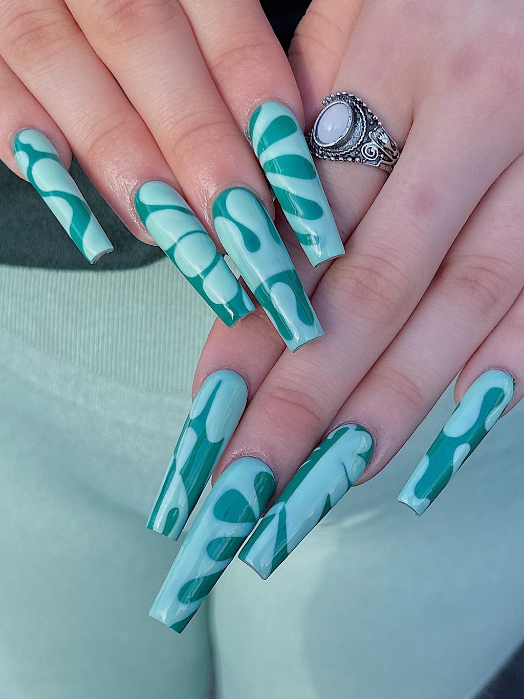 Teal coffin nails feature a tropical palm leaf pattern at Palace Nail Spa in Tallahassee