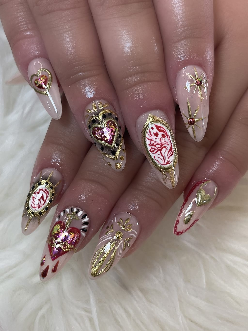 Nude and gold nails with red heart accents at Palace Nail Spa in Midtown Tallahassee