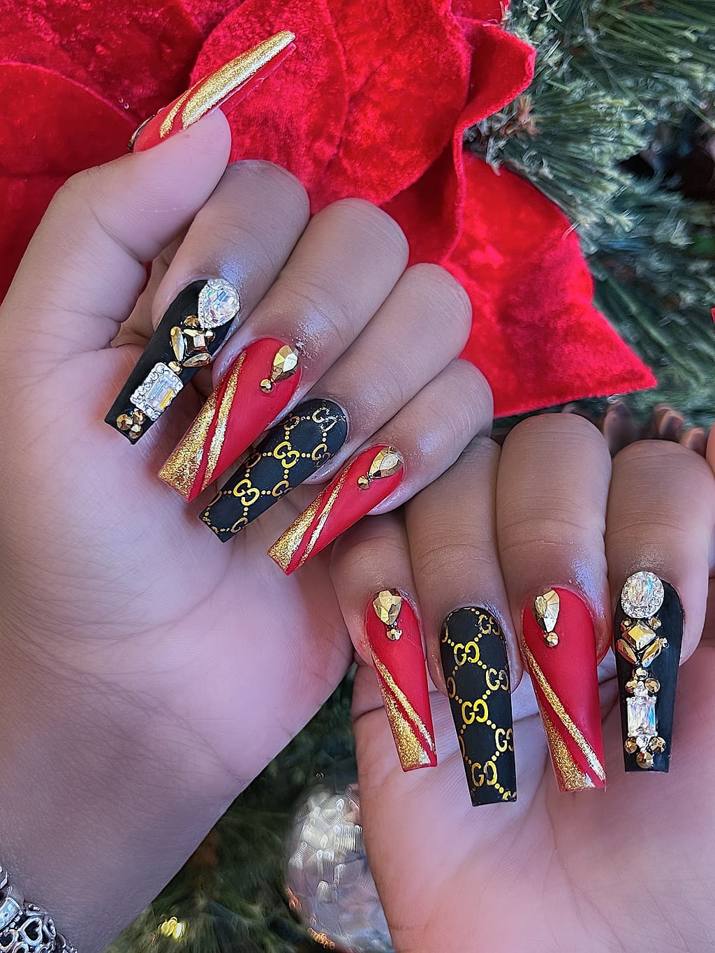 Red and black coffin nails feature gold chrome swirls at Palace Nail Spa in Midtown Tallahassee