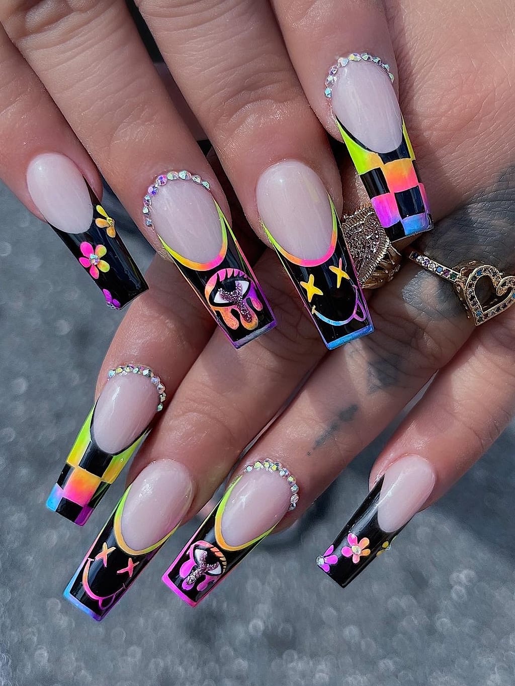 Colorful checkered French tip coffin nails with charms and gems at Palace Nail Spa in Tallahassee