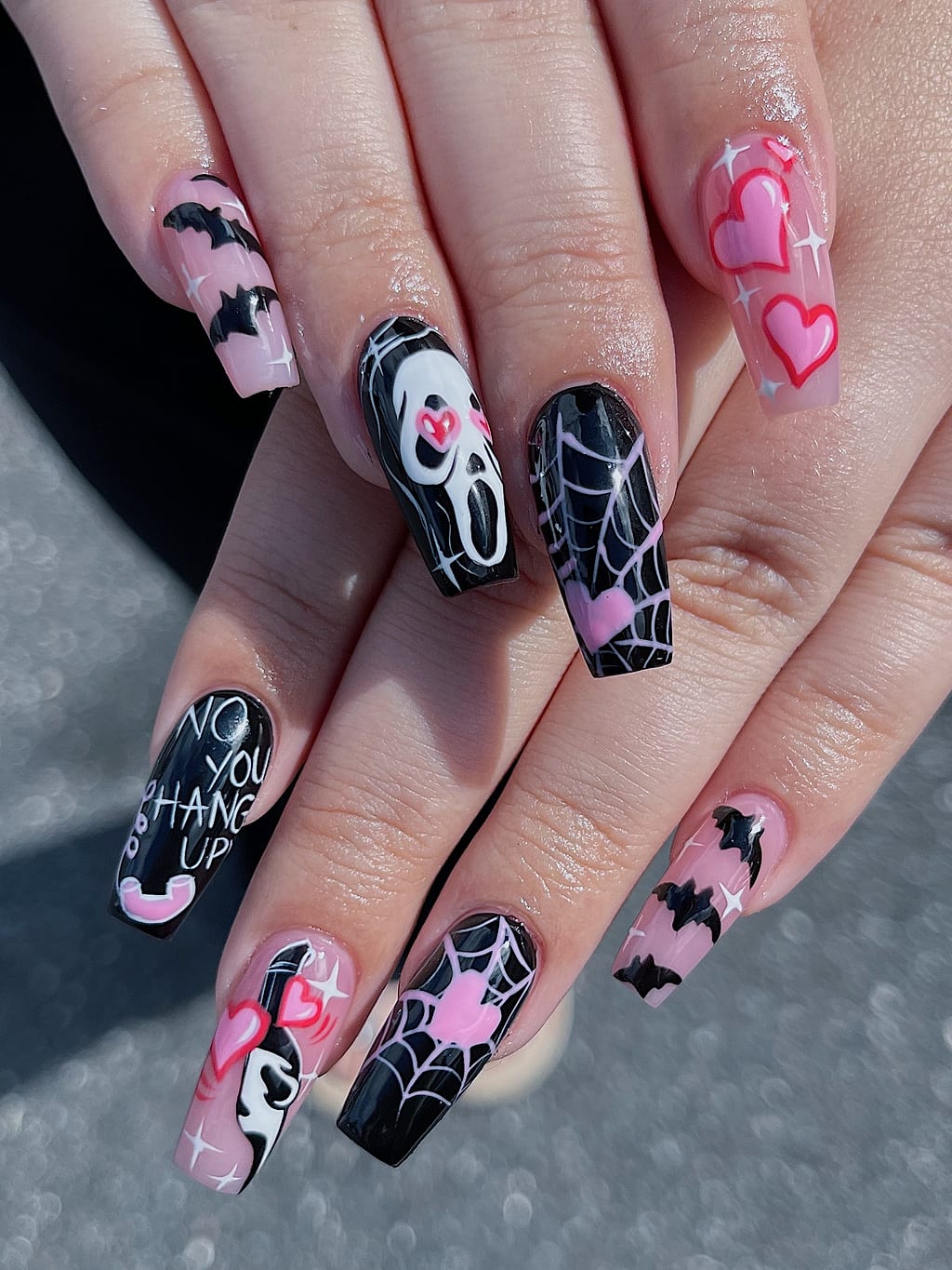 Black and pink coffin nails feature Halloween spiderwebs bats and hearts at Palace Nail Spa