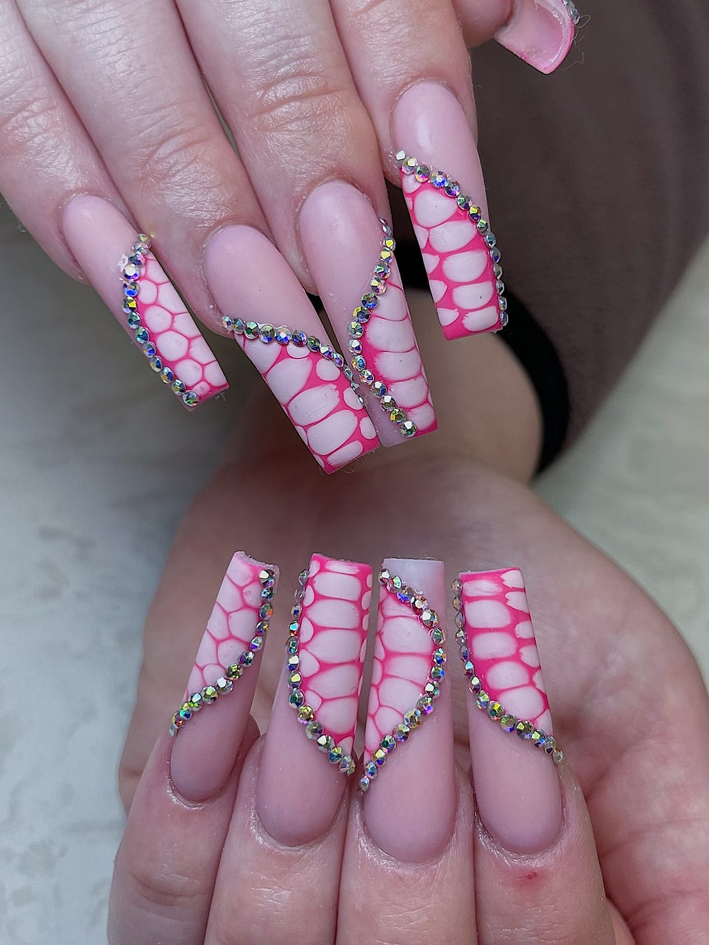Clear coffin nails feature a pink lace spiderweb design at Palace Nail Spa in Midtown Tallahassee