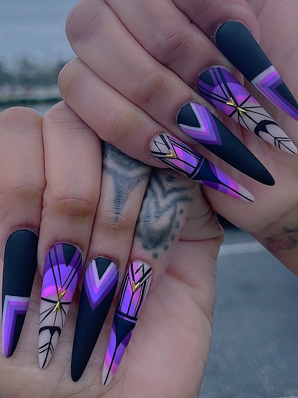 Black coffin nails with a sharp purple geometric pattern at Palace Nail Spa in Midtown Tallahassee