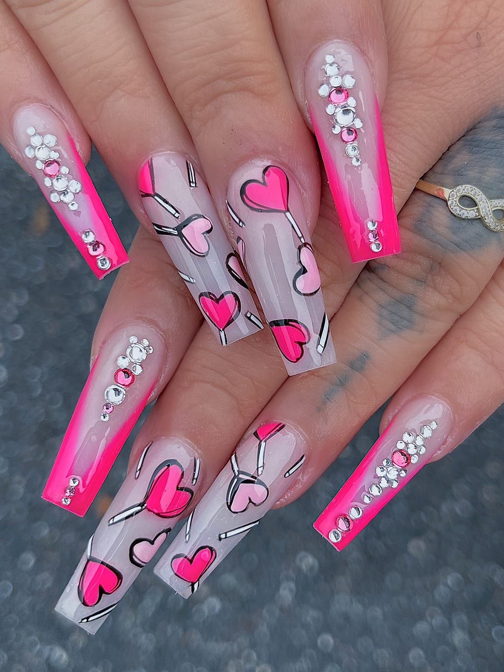 Hot pink coffin nails feature heart outlines, rhinestone accents at Palace Nail Spa in Midtown Tallahassee