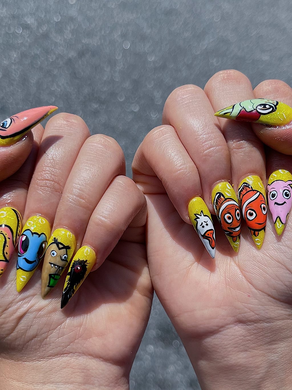 Yellow and orange coffin nails feature cartoon fish characters at Palace Nail Spa in Midtown Tallahassee