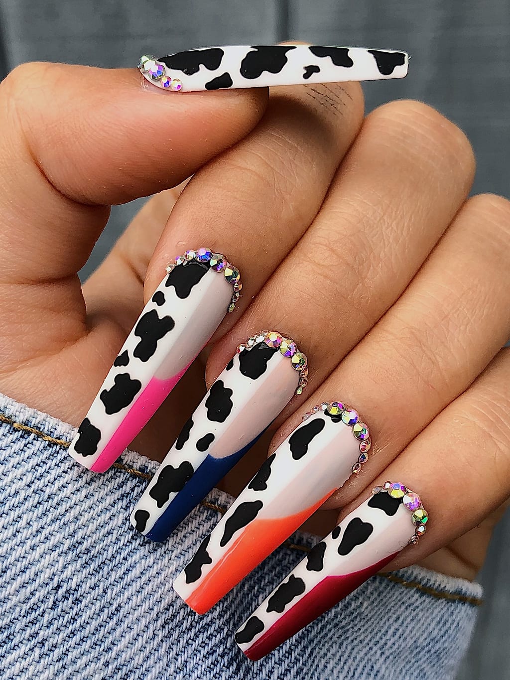 Cow print coffin nails with an orange tip accent at Palace Nail Spa in Midtown Tallahassee