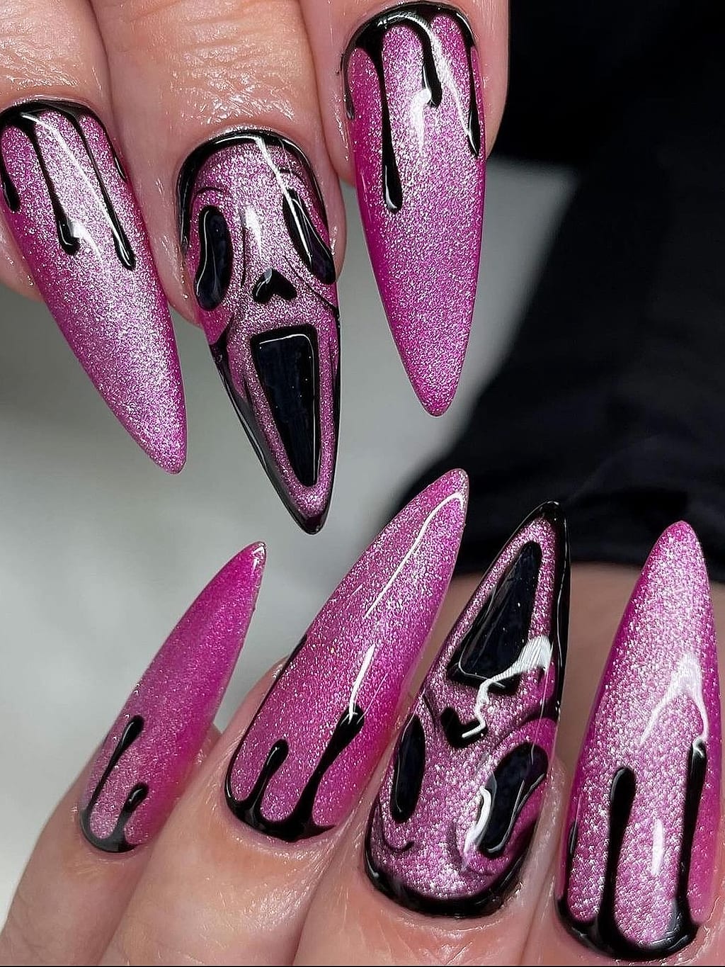Pink glitter stiletto nails with black ghost face design at Palace Nail Spa in Midtown Tallahassee