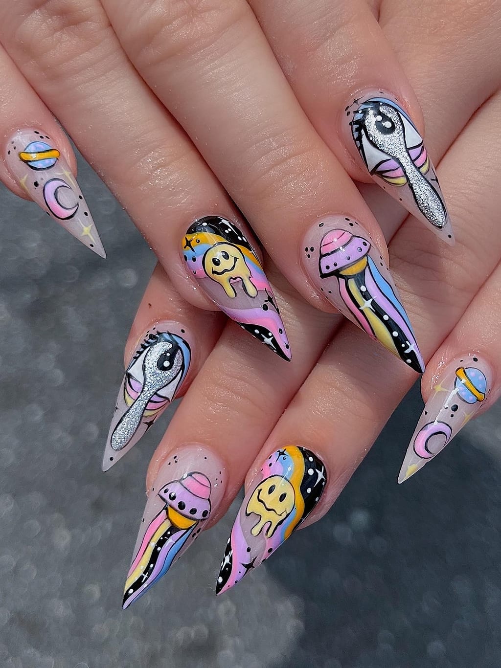 Nude almond nails with whimsical cartoon character art at Palace Nail Spa in Tallahassee