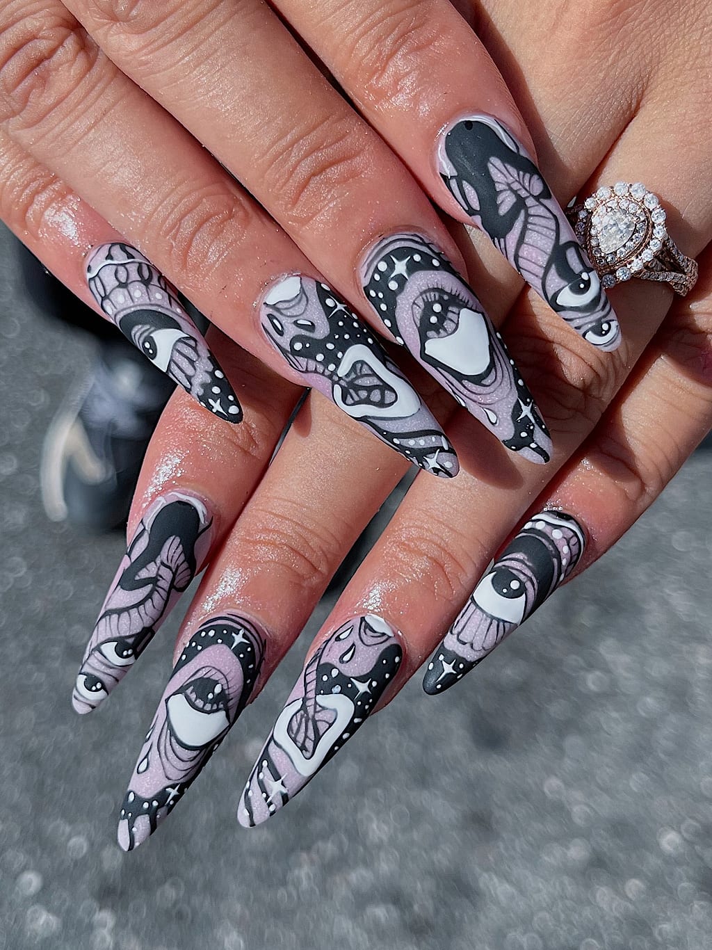 Black and white stiletto nails with comic cartoon art at Palace Nail Spa in Midtown Tallahassee