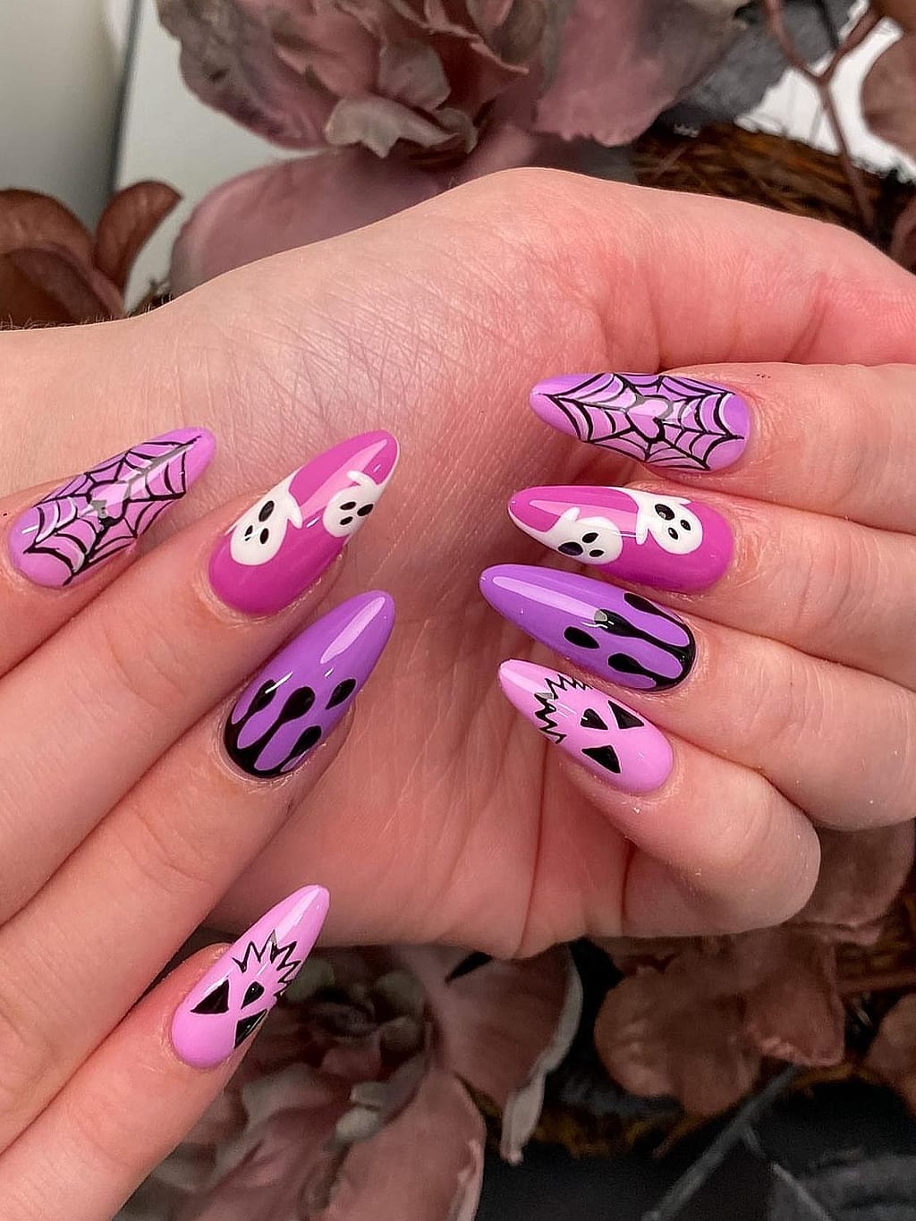 Pink and purple almond nails with spiderweb and skull art at Palace Nail Spa