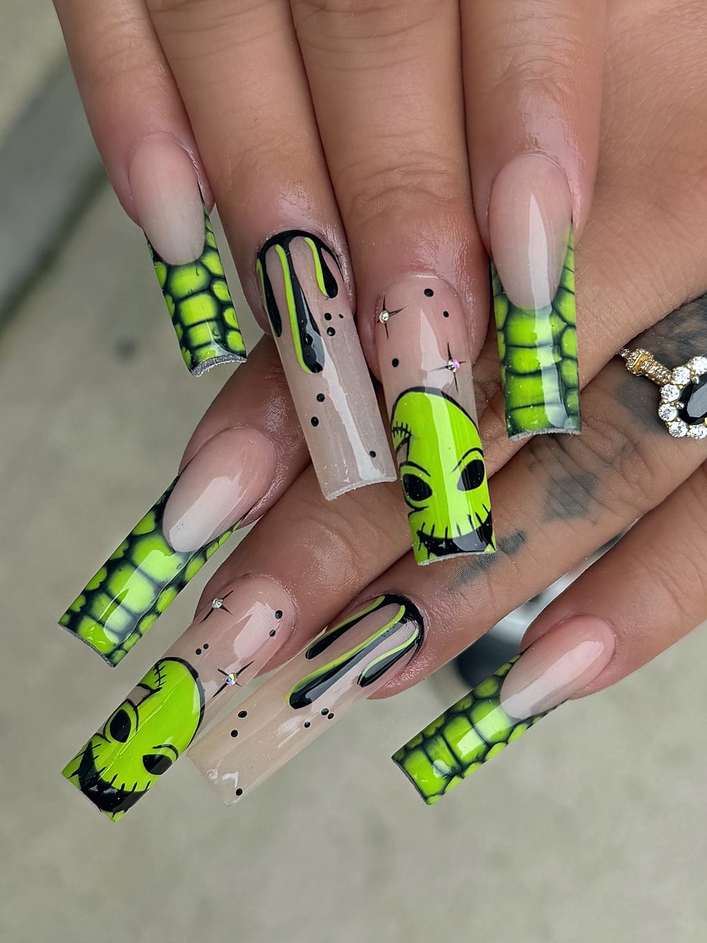 Nude coffin nails with neon green spiderweb and skull art at Palace Nail Spa in Tallahassee