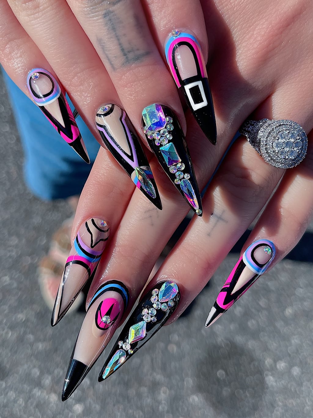 Blue and pink chrome stiletto nails with gothic buckle art at Palace Nail Spa