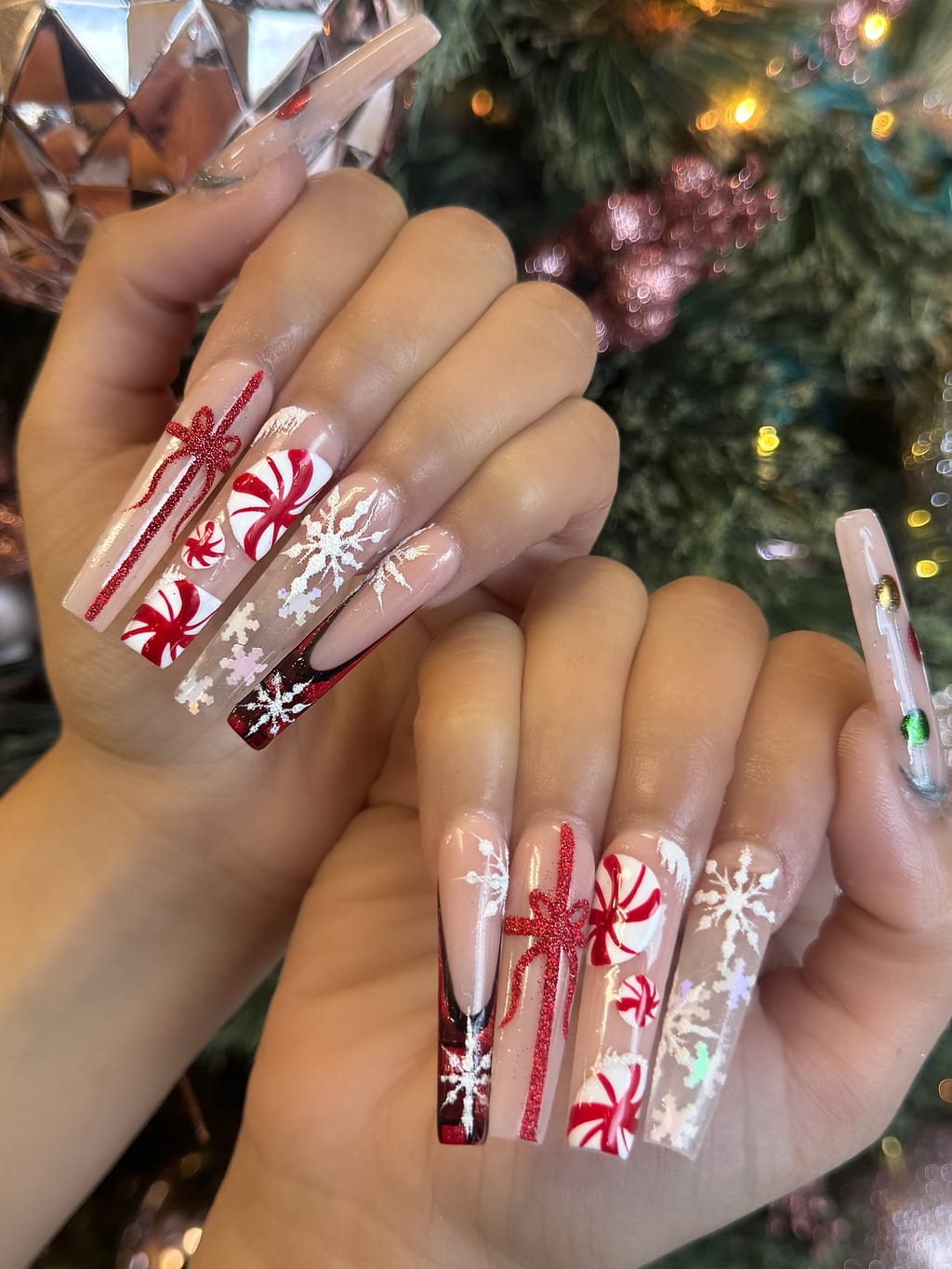 White and nude coffin nails with red holiday snowflake art at Palace Nail Spa in Midtown Tallahassee