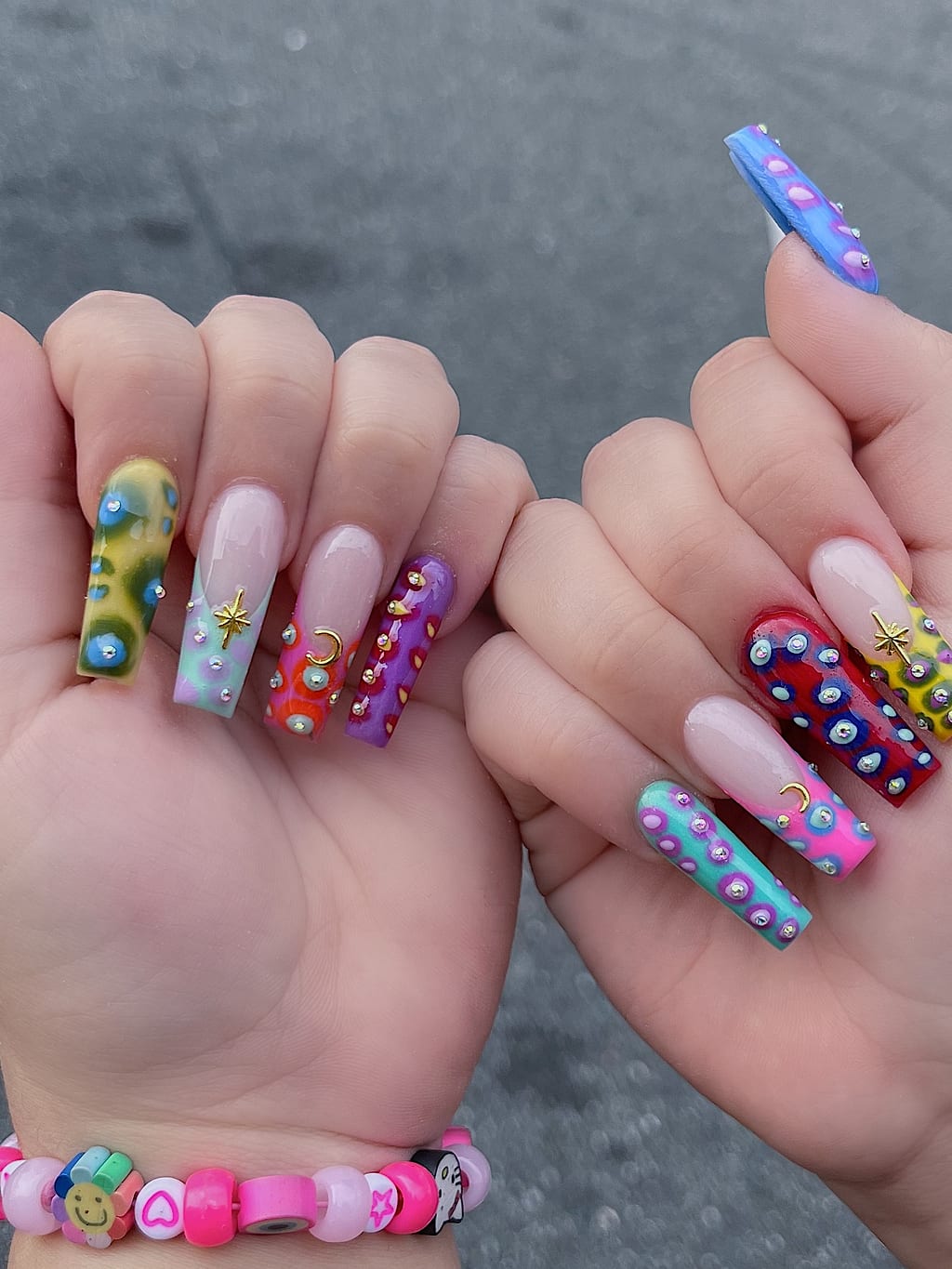 Short nails mixing painted portraits, polka dots, and bright colors at Palace Nail Spa in Tallahassee